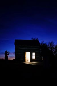 Silhouette of house against clear sky at night