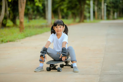 Cute little girl asia playing skateboard or surf skate in the skate park.