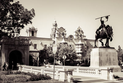 Statue in city against clear sky