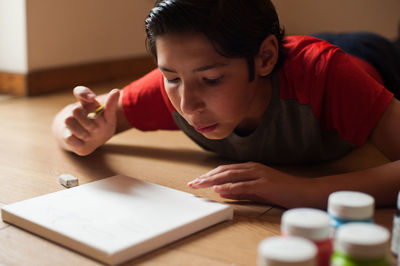 Boy looking away while sitting on table