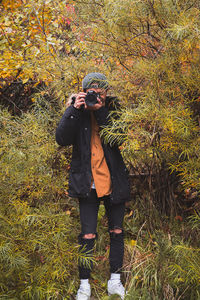 Full length of senior woman standing on street during autumn