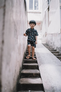 Full length of boy standing on staircase