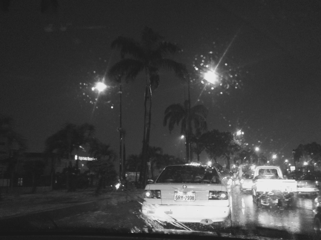 CARS ON ROAD AGAINST ILLUMINATED STREET LIGHTS AT NIGHT