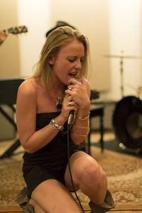Young female singer rehearsing with her band