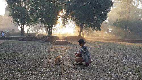 Woman with dog sitting on plant