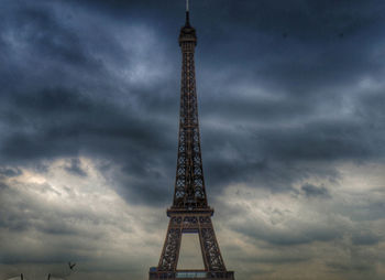Low angle view of eiffel tower against cloudy sky