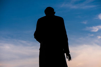 Silhouette man standing against sky during sunset