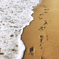 High angle view of footprints on sand at beach