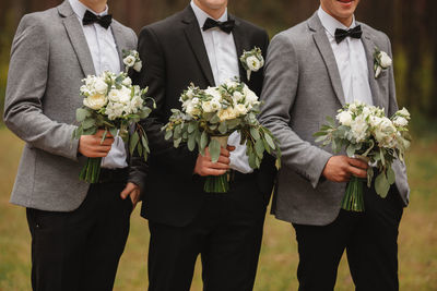 Rear view of people holding flower bouquet