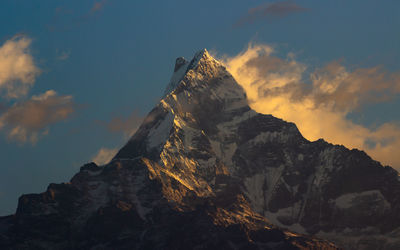 Low angle view of rock formation against sky during winter