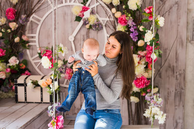 Woman with flowers against plants