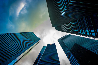 Low angle view of modern building against cloudy sky