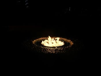 Close-up of lit candle over black background