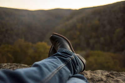 Low section of man resting against mountain