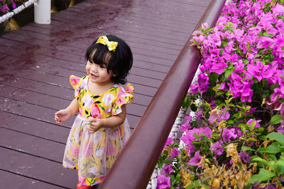 Full length of woman standing against pink flowering plants