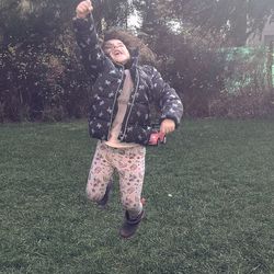 Full length of happy woman standing on field