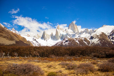 Scenic view of snowcapped mountains against blue sky