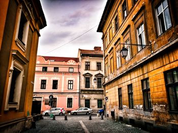 Cars on street in city against sky