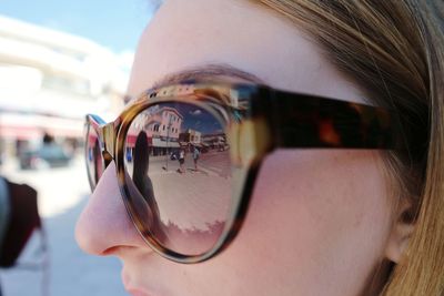 Close-up of woman wearing sunglasses in city