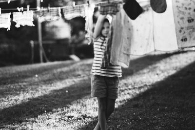 Girl drying clothes on clothesline at back yard