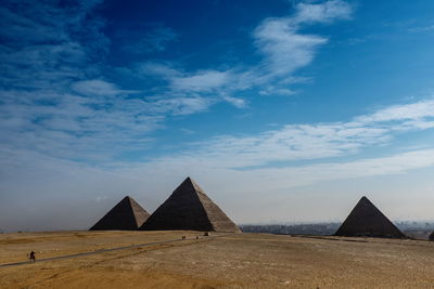 Pyramids against cloudy blue sky