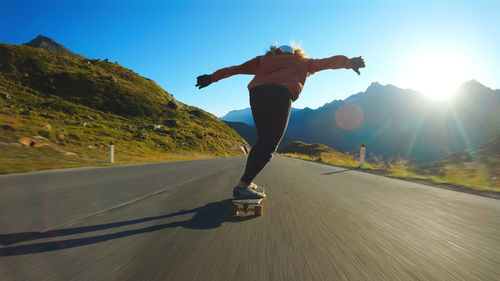 Rear view of man exercising on road