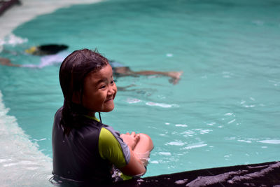 Girl sitting in swimming pool