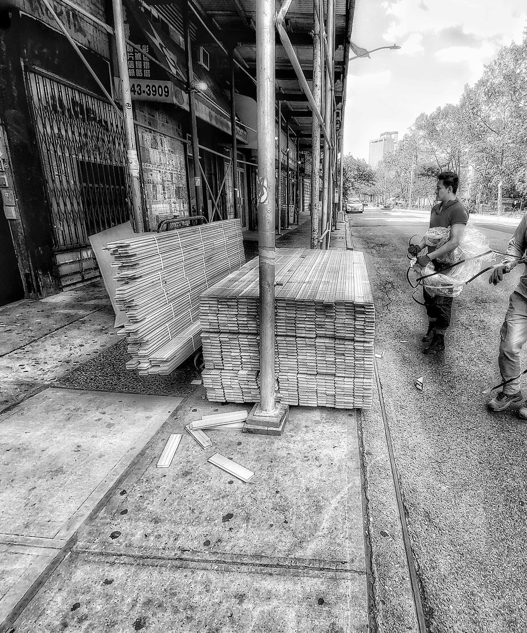 MAN SITTING ON BENCH BY BUILDING