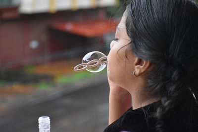 Close-up portrait of girl holding bubbles