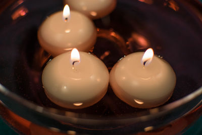 Close-up of illuminated candles in container