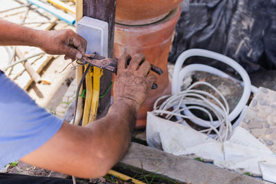 Electrician binding copper wires together and sealing them with insulation stripe.