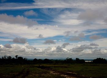 Scenic view of field against cloudy sky