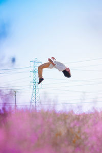 Woman with flowers against clear sky