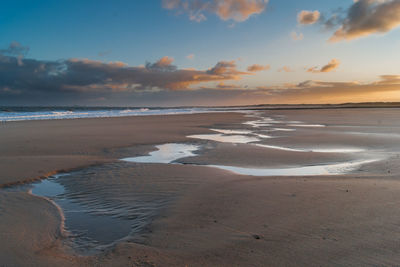 Scenic view of beach against sky during sunset