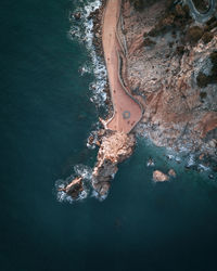 High angle view of rock formation and walkway by the beach