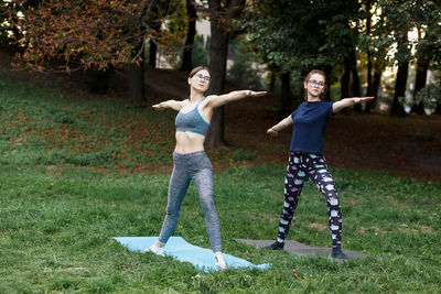The relaxed girls is doing yoga in the park on carpet