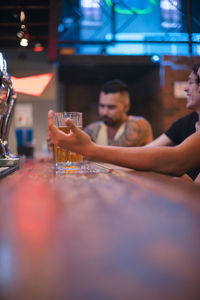 Midsection of man drinking glass on table