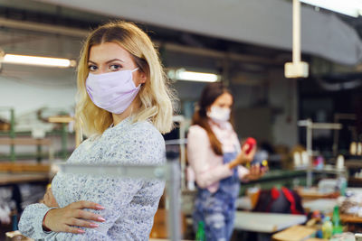 Portrait of woman wearing mask in textile factory