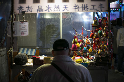 Rear view of man at market stall