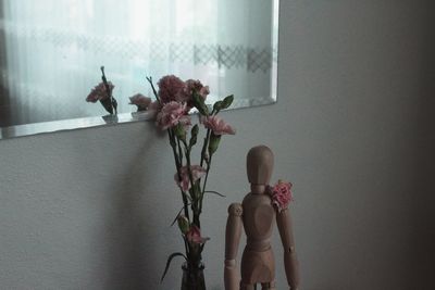 Close-up of flower vase on table against wall at home