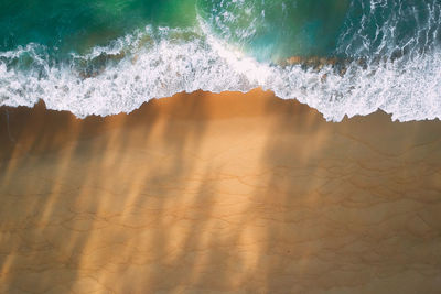 Aerial view of wave rushing towards beach