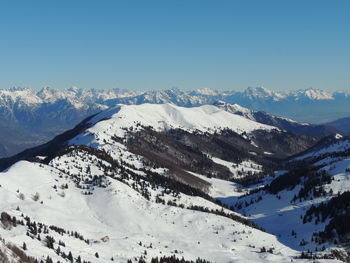 Scenic view of snowcapped mountains against clear blue sky