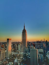 View of city lit up against blue sky