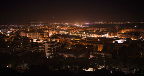 High angle view of illuminated buildings in city at night