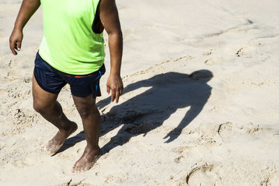 Lower part of a person and his shadow on the beach sand. salvador bahia brazil.