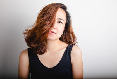 Portrait of beautiful young woman against white background