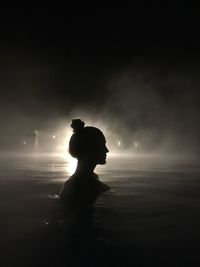 Silhouette people on beach against sky at night