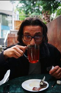 Portrait of mature man drinking herbal tea at sidewalk cafe