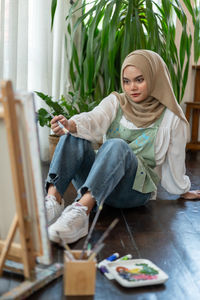 Portrait of young woman sitting on table