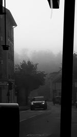 Cars on city street against sky